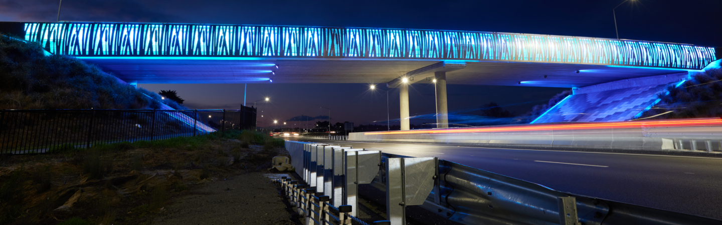 Bridge across motorway with colourful light patterns